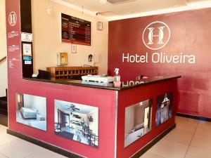 伊帕廷加Hotel Oliveira - By UP Hotel的酒店大堂设有酒店olivia标志
