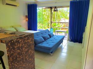 马塞约Bangalô Villas do Pratagy com jacuzzi的客厅配有蓝色的沙发和蓝色的窗帘