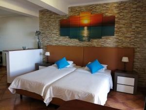 丰沙尔Apartments Vista Oceano的一间卧室设有两张床,墙上挂着一幅画