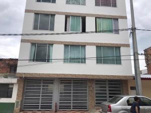 富萨加苏加Hermoso apartamento con parqueadero的前面有停车位的建筑