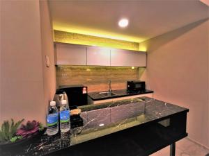 新山Prestigo Hotel - Johor Bharu的厨房配有柜台上的瓶装水