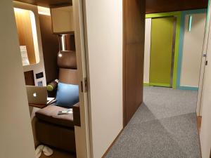 多哈sleep 'n fly Sleep Lounge, SOUTH Node - TRANSIT ONLY的一间设有门的房间,可通往带笔记本电脑的房间