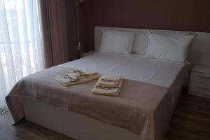 戈采代尔切夫Къща Мариана的一张带两条毛巾的床和一个托盘