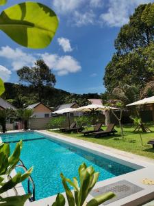 珍南海滩The Temak Villa的庭院内一个带椅子和遮阳伞的游泳池