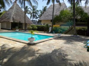 迪亚尼海滩Glory Ocean Villas - Diani的棕榈树屋前的游泳池