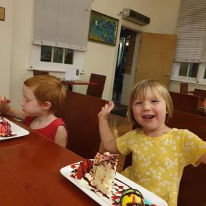 洛坎普顿丽晶罗克汉普顿品质酒店的两个孩子坐在桌子上,拿着一块蛋糕