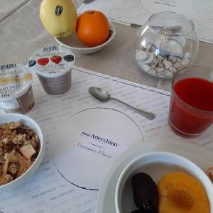 里乔内Hotel Arlecchino Riccione的一张桌子,上面放着一盘食物和一碗水果