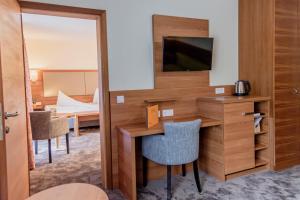 巴德哥依斯恩乌尔福赫格伊斯尔姆勒酒店的酒店客房配有书桌和电视。