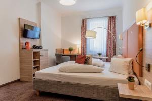 巴德哥依斯恩乌尔福赫格伊斯尔姆勒酒店的酒店客房设有一张大床和一张书桌。
