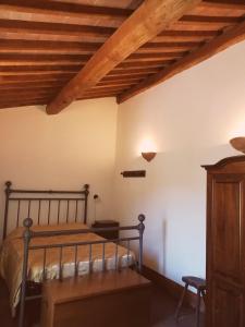 AlleronaAgriturismo Selvella的一间卧室设有一张床和木制天花板