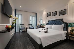 下龙湾Ha Long Essence Hotel的一间卧室配有一张白色大床和蓝色床头板