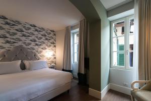 斯特雷萨贝唯酒店的一间卧室设有一张床和两个窗户。