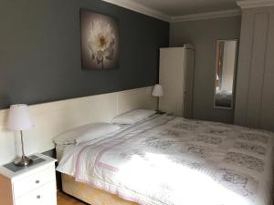 莫纳汉Grove Lodge B&B的卧室配有白色的床,墙上挂着白色花朵