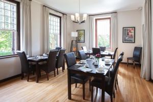 埃尔金Elgin Vintners Country House的用餐室设有桌椅和窗户。