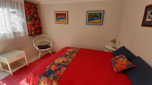 GlencairnSelf catering Holiday Apartment的一间卧室配有红色的床和椅子