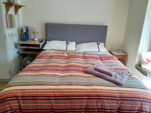 格兰瑟姆Spacious King Bedroom in Grantham Lincolnshire的床上有五颜六色的毯子