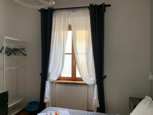 阿雷佐San Domenico House的一间卧室设有窗户、窗帘和一张床