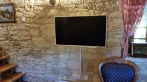VinicaHiža Golubić的挂在石墙上的平面电视