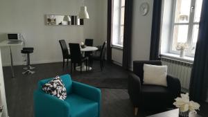 梅斯Le FOURNIRUE T2的客厅配有蓝色椅子和桌子