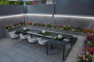 尼亚·卡利克拉提亚S. Luxury Princess Suite的庭院设有两把桌子和椅子,鲜花盛开