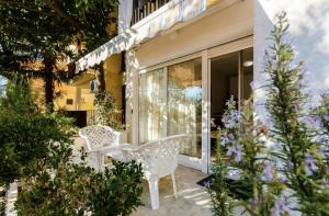 贝西奇Mandarin Apartments的庭院设有两把白色椅子和鲜花