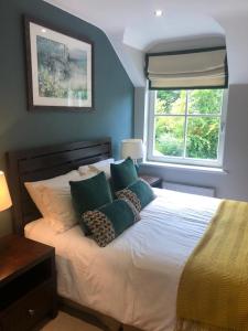 肯梅尔Cromwells Court的卧室配有带枕头的床铺和窗户。