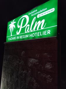 赛比什Palm Rezidential的砖墙上的浅色酒店绿意盎然的标志