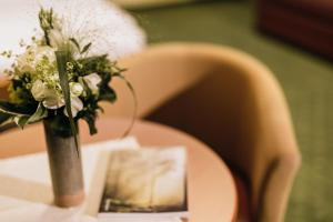 克里格拉赫Gasthof Rothwangl Hannes的花瓶,花瓶上满是白色的花朵,坐在桌子上