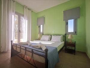 希伊Xi House的一间卧室设有一张带绿色墙壁和窗户的床。