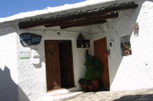布维翁Apartamentos y Casas Rurales Las Terrazas de la Alpujarra的白色的建筑,有门和标志