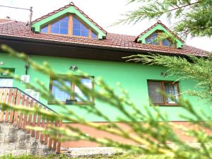 克伦特尼采Penzion Villa Verde Moravia的绿色房子,设有红色的屋顶和窗户