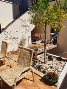 圣若昂达博阿维斯塔Hotel Magnólia的庭院配有两把椅子和桌子,树木繁茂
