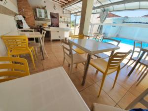 圣若昂达博阿维斯塔Hotel Magnólia的一个带桌椅的用餐室和一个游泳池