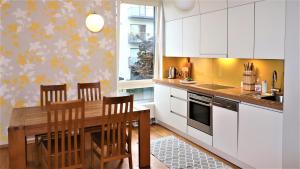塔林Fabulous Location Apartments的厨房配有白色橱柜和木桌