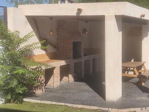 Cadalso de los VidriosCasa Rural Mirando a Gredos的一个带桌子和长凳的有盖庭院