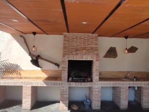 Cadalso de los VidriosCasa Rural Mirando a Gredos的客厅设有砖砌壁炉,配有天花板