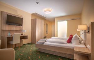 伦布鲁Hotel Garni Zur Alten Post的酒店客房配有一张床、一张书桌和一台电视。