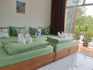 梭桃邑บ้านสวนนิสา的带窗户的客房内设有两张单人床。