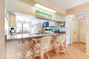 霍姆斯海滩Beach View 5的厨房配有2把吧台凳和台面
