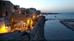 马利耶B&B Salento il VianDante的夜晚可欣赏城市和大海的景色