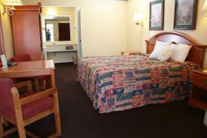 克莱尔莫尔克莱尔莫尔汽车旅馆的酒店客房配有一张床、一张桌子和一把椅子。