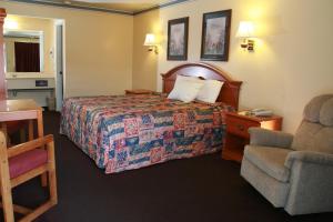 克莱尔莫尔克莱尔莫尔汽车旅馆的配有一张床和一把椅子的酒店客房