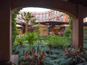 菲亚纳兰楚阿Zomatel Hotel的庭院中种有植物的拱门和一座建筑