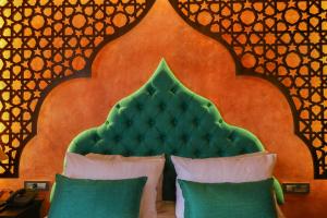 罗德镇DECAN Concept Boutique Estate的一张带绿色床头板的床和两个枕头