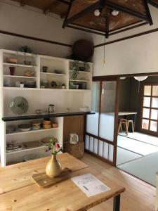 樱井市あまね庵 Villa Amane的一间设有木桌的房间,上面有花瓶