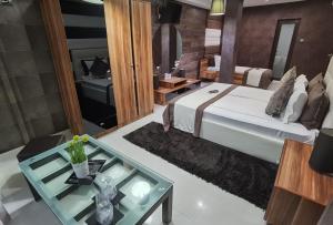 舒门阿克申酒店的一间卧室配有一张床和一张玻璃桌