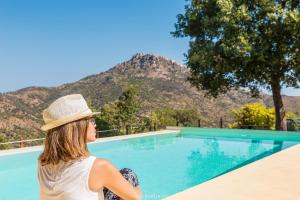 波利纳Casale Margherita Turismo Rurale的坐在游泳池旁戴帽子的女人