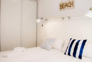 萨洛Domatsea Salou Mediterrani的白色的床和蓝色的白色枕头