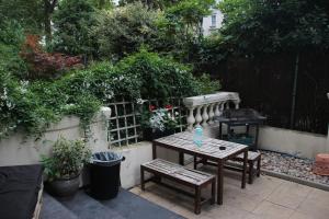 伦敦Onefam Notting Hill的后院的庭院设有桌子和烧烤架。