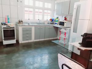坎皮纳斯Franca Maya Hostel的白色的厨房设有水槽和炉灶。